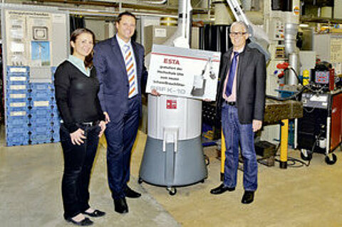 Prof. Dr. Manfred Wehrheim von der Hochschule Ulm bekommt von Jessica Kulitz und Philipp Raunitschke einen MULTISOG überreicht.