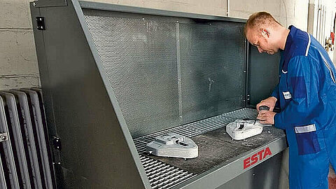 Ein Arbeiter schleift Material auf dem Absaugtisch AV, welcher sich für Prozesse wie Schweissen und Schleifen eignet Ein Arbeiter schleift Material auf dem Absaugtisch AV, welcher sich für Prozesse wie Schweissen und Schleifen eignet